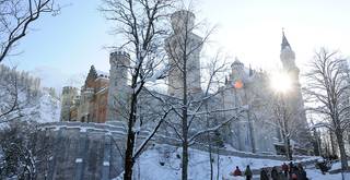 Laufen Sie in Ihrem Winterurlaub im Allgäu auf das Schloss Neuschwanstein und bewundern Sie auf dem Weg die verschneiten Allgäuer Berge.